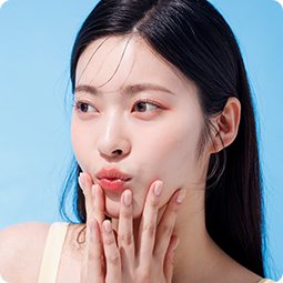 셀피 후기 사진 — 입술을 내민 긴 생머리 여성(하늘색 바탕)