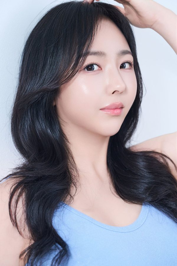 머리에 손을 올린 긴 웨이브 머리 여성 모델(하늘색 민소매) — 수술 과목 카드(트임수술)