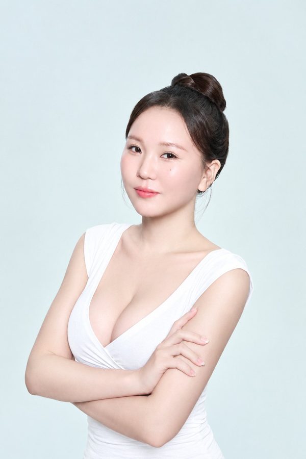 팔짱 낀 흰 브이넥 상의 여성 모델 — 수술 과목 카드(가슴확대)
